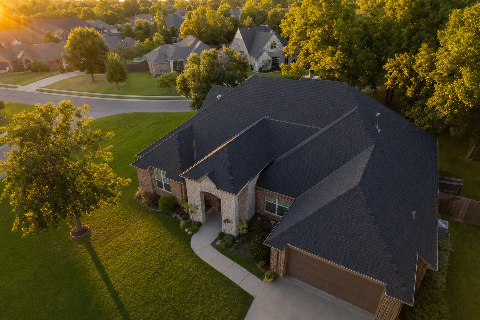 Aerial view of a home in the Tulsa area with a newly installed dark architectural shingle roof