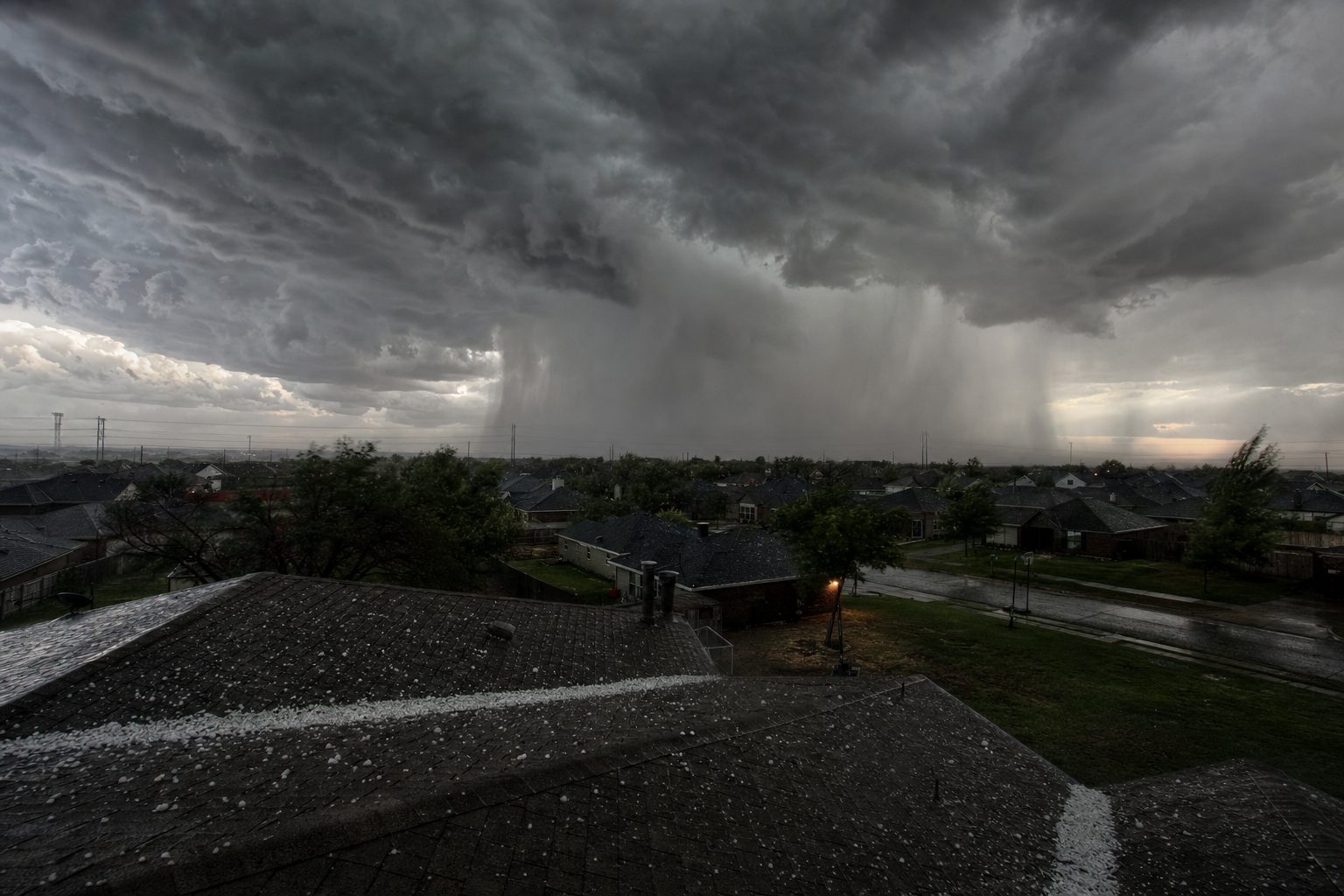 Dark storm clouds and hail rolling over an Oklahoma neighborhood